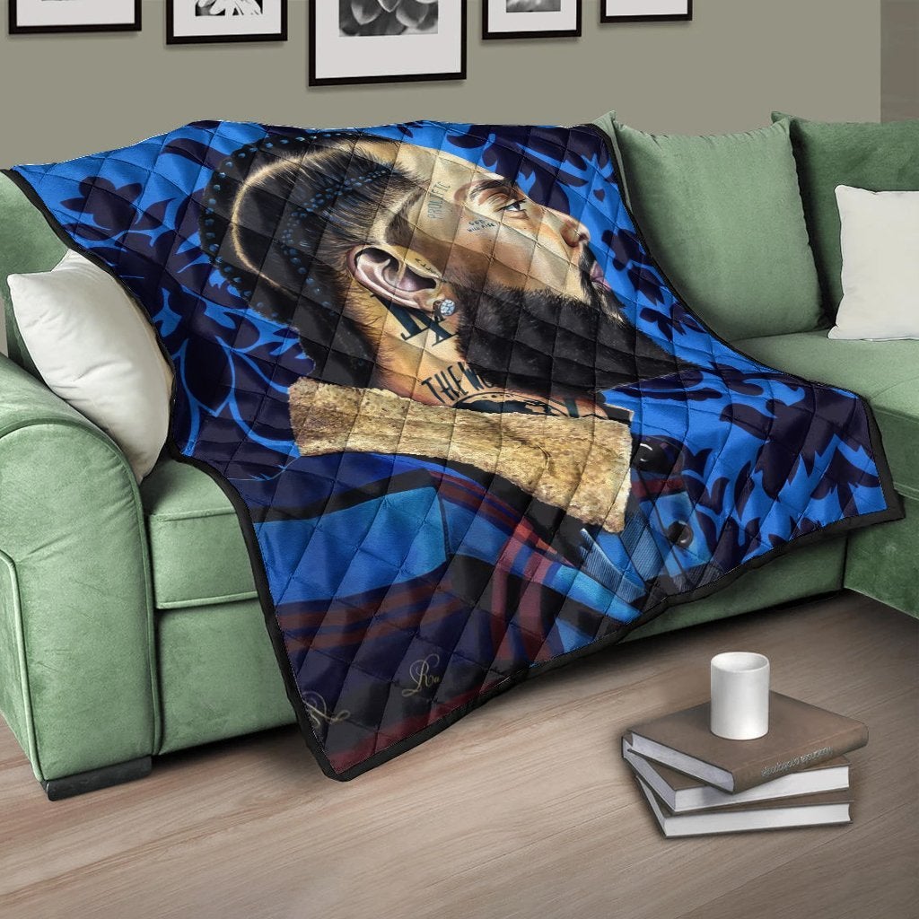 Multicolor quilt with bold blue pattern and face graphic, draped over couch