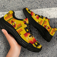Close-up side view: yellow chunky sneakers with red-and-black geometric tribal print