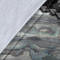 Close-up of white blanket edge with gray and muted teal printed design