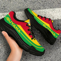 Close-up side angle of Guyana flag chunky sneakers; black sole, red and yellow panels with green stripe