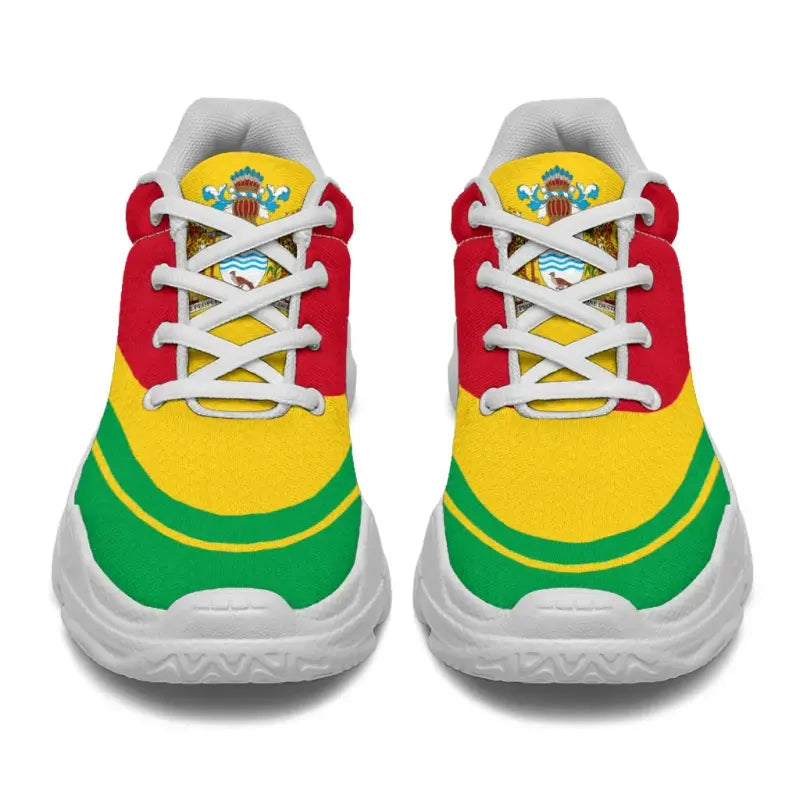Pair of Guyana flag chunky sneakers, front view; white sole, red upper with green and yellow bands