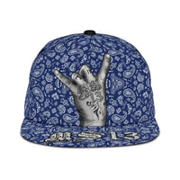 Blue snapback hat close-up with paisley bandana print and gray hand on crown