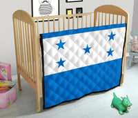 Blue and white star quilt on a crib, diamond-quilted with white stripe