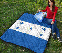 Blue and white star quilt laid on grass, diamond quilt texture