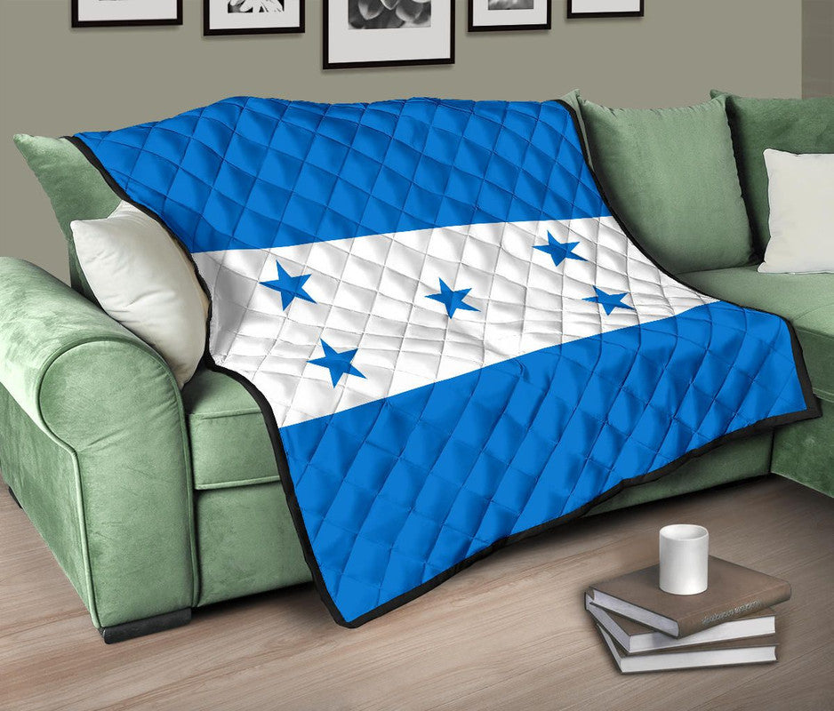 Blue quilt with white star stripe panel and diamond stitching, black-edged trim.