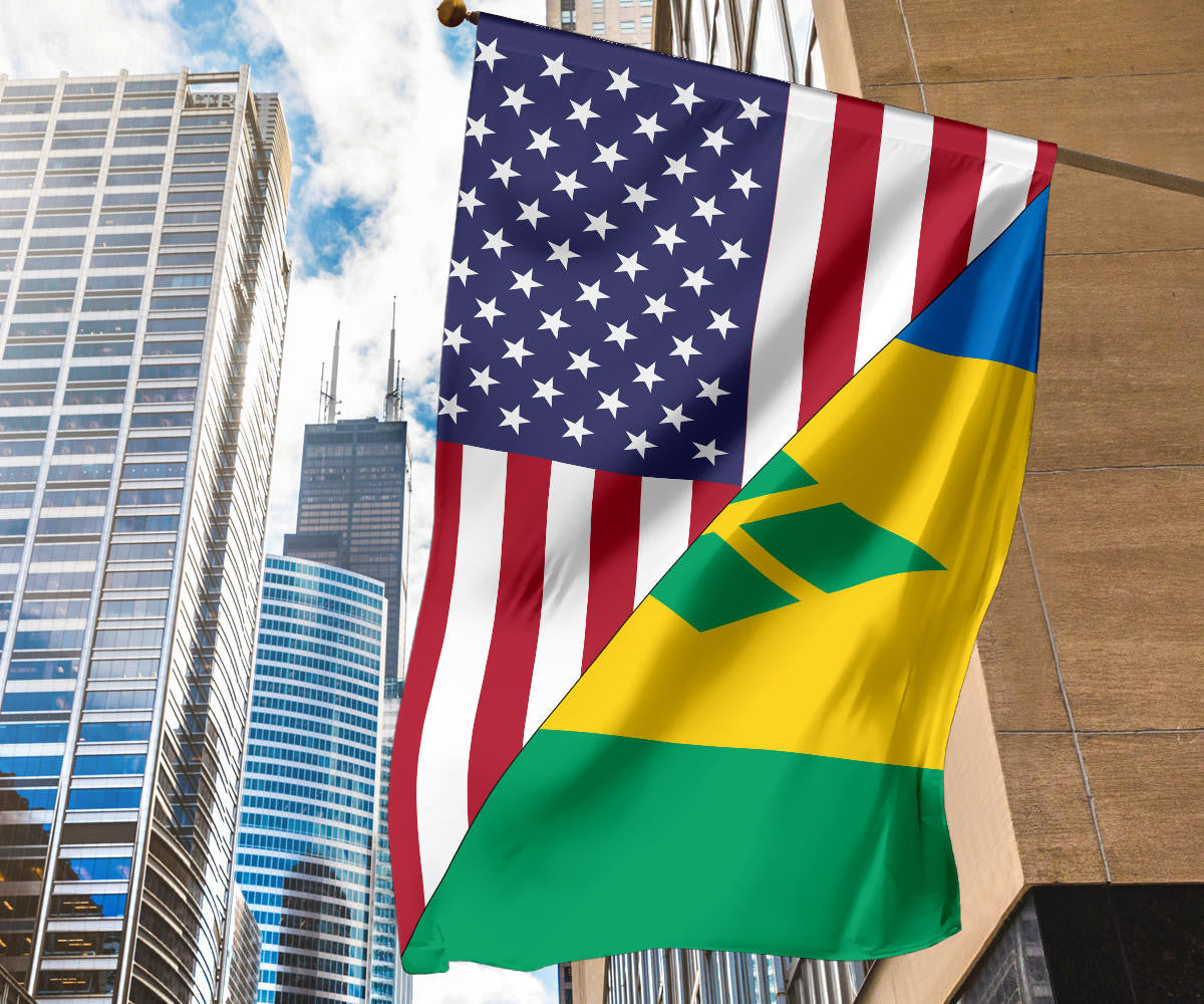 Tall flag flying from building mast with US stars, stripes, and Saint Vincent green-yellow-blue