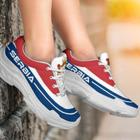 Chunky sneakers on feet: red white and blue uppers with white laces, white sole tread