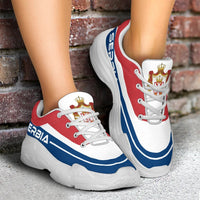 Chunky lace-up sneakers with red and white panels, blue stripe, white sole, side view
