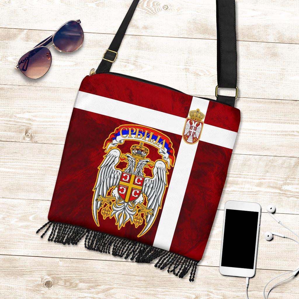 Red crossbody bag with Serbia crest, white panel stripe, black fringe along bottom edge