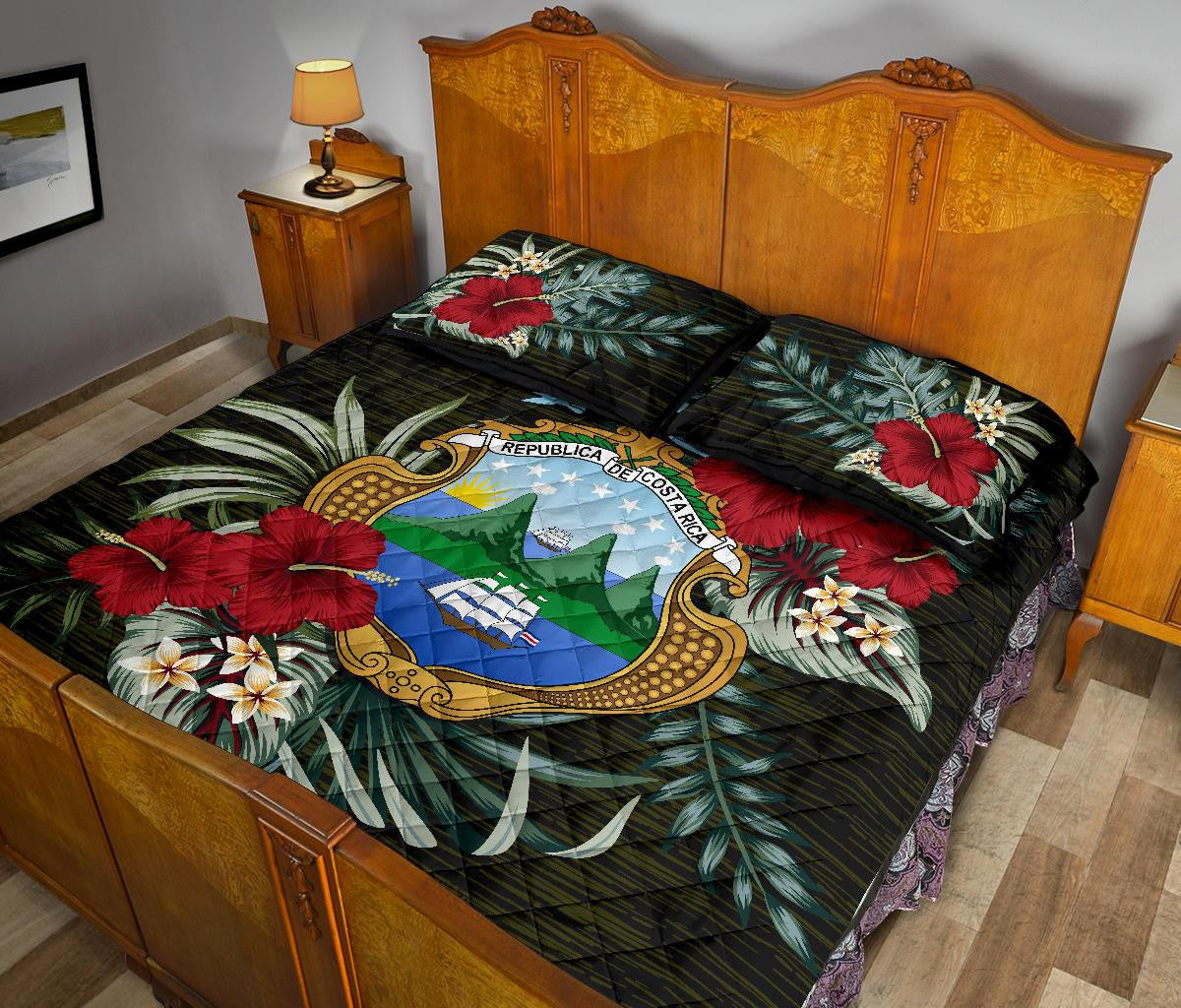 Black quilt bed set with Costa Rica emblem, red hibiscus blooms and tropical leaf pattern