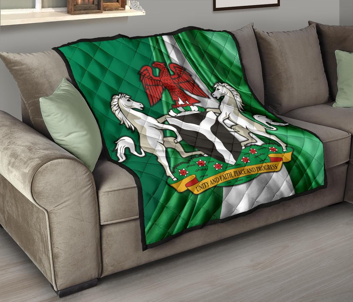 Green Nigerian quilt with coat of arms design: eagle, two horses, and unity banner
