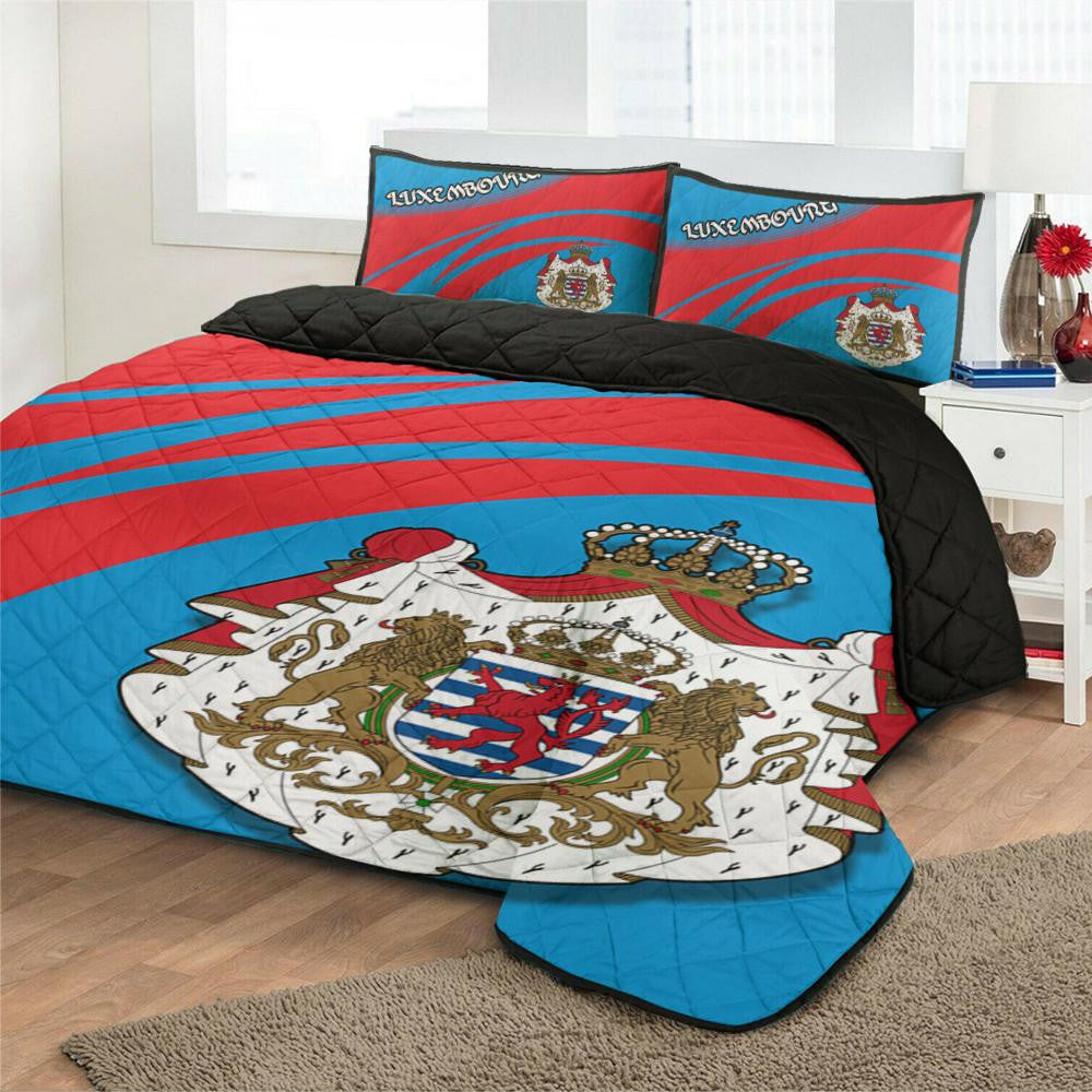 Blue/red quilt bed set with large coat-of-arms shield on duvet and two crest pillows