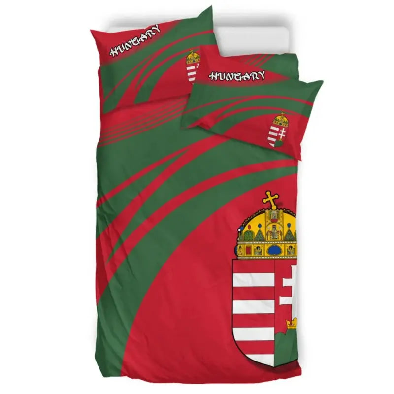 Red and green duvet with partial coat-of-arms shield, flanked by printed pillows