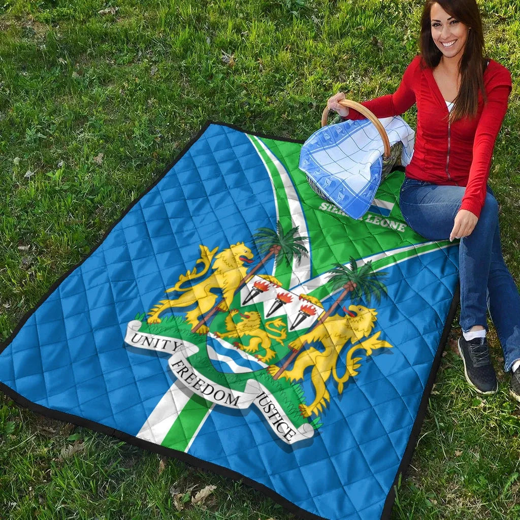 Sierra Leone pride quilt on grass, blue and green quilted flag with central crest
