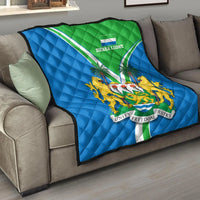 Sierra Leone pride quilt on sofa, blue and green quilted flag with crest emblem