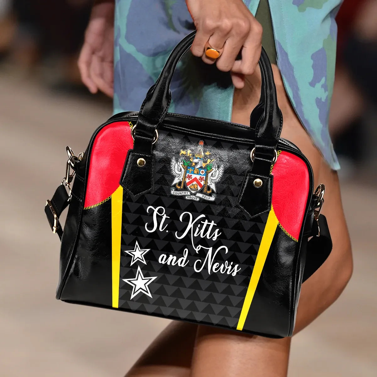 Black handbag with red sides, yellow stripes, crest front panel, top handles