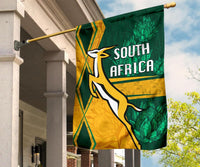 South Africa flag on wall-mounted pole, green and gold “SOUTH AFRICA” with springbok