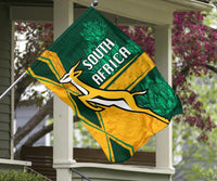 South Africa flag hanging on porch, green and gold springbok with “SOUTH AFRICA”