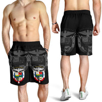 Black shorts with crest print, worn by model; elastic waistband