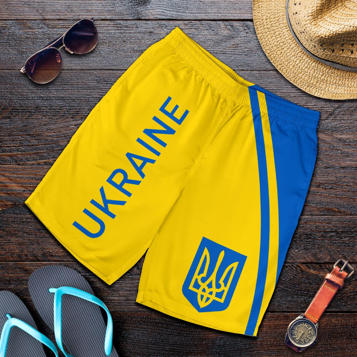 Flat-lay men's yellow Ukraine shorts with blue stripe, 'UKRAINE' lettering and trident logo