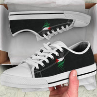 White low-top sneakers close-up, green/red graphic on black panel, white sole stripe