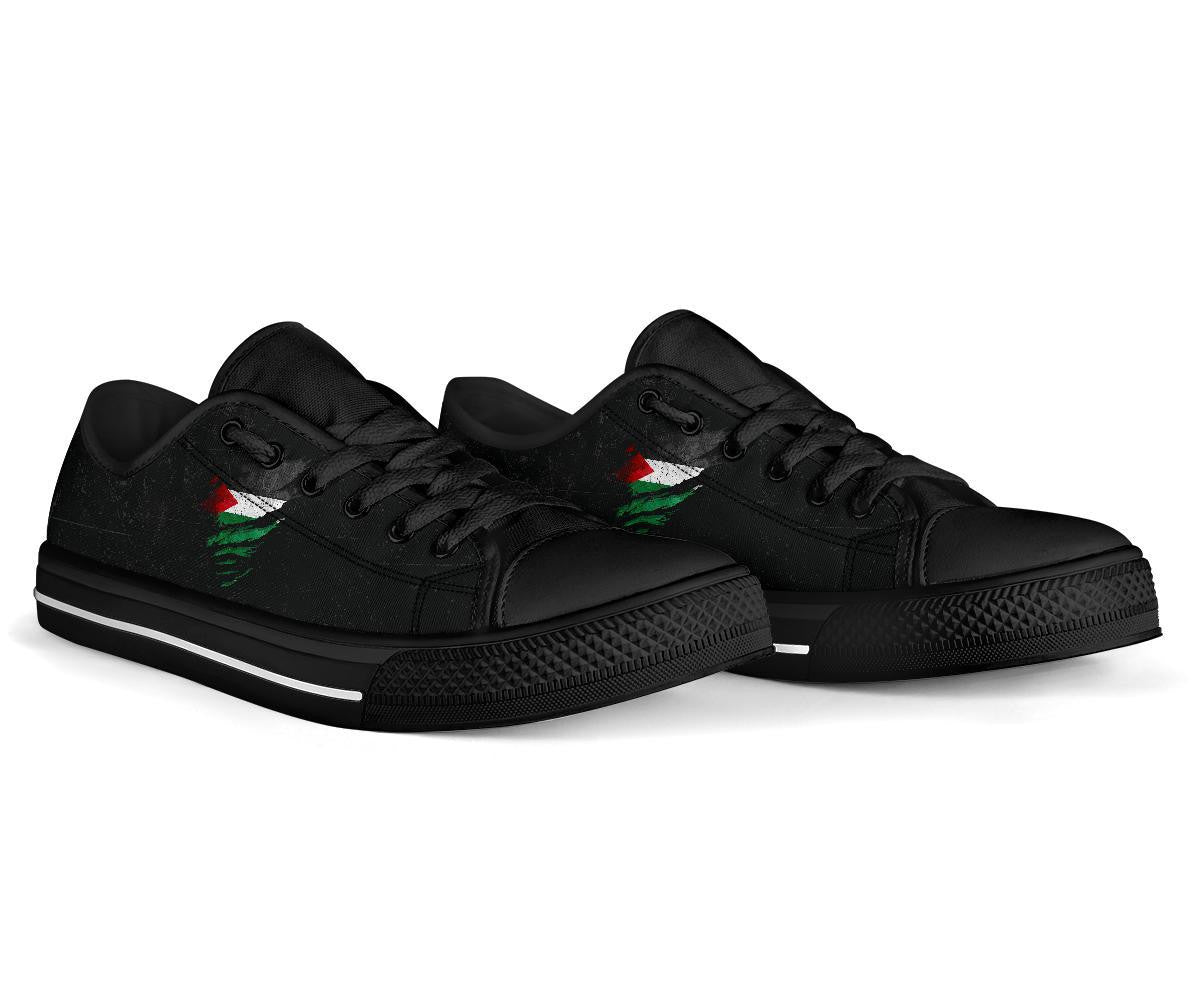 Black low-top sneakers side view, black laces, green/red flag-style graphic
