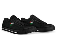 Black low-top sneakers side view, black laces, green/red flag-style graphic