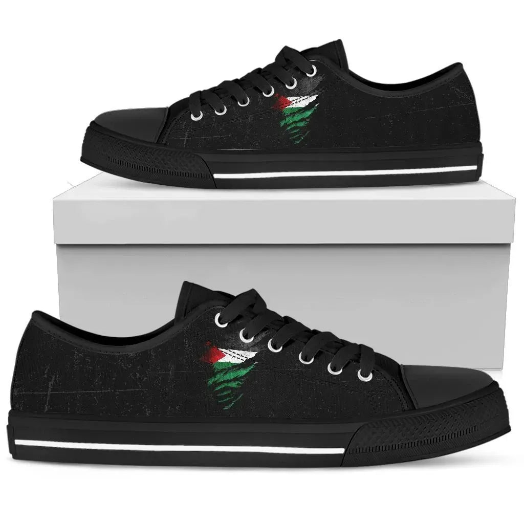 Black low-top sneakers, black laces, green/red graphic on side, grunge style