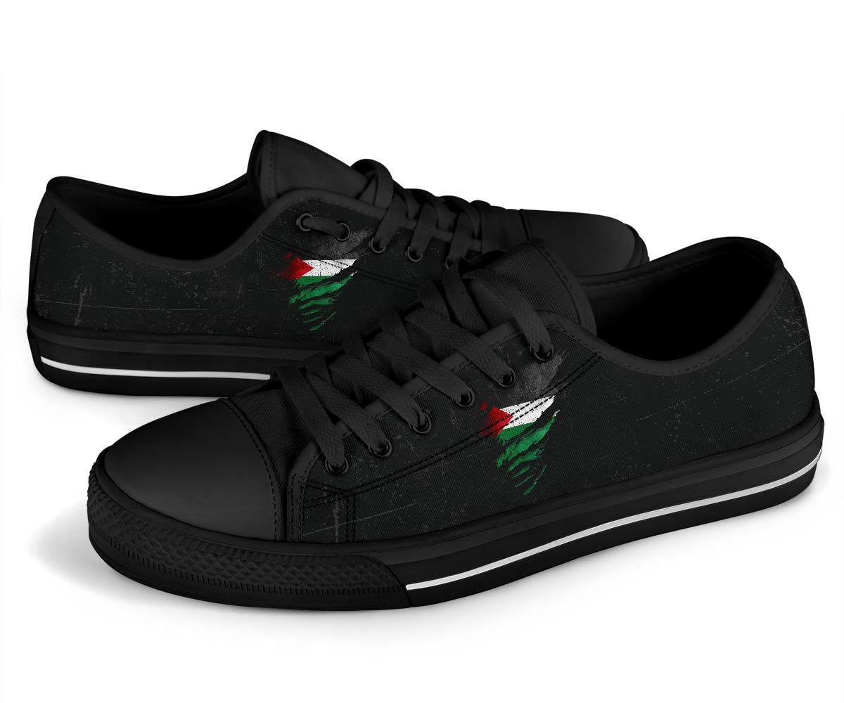 Black low-top sneakers front view, black laces, green/red distressed graphic