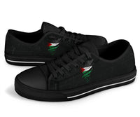 Black low-top sneakers front view, black laces, green/red distressed graphic