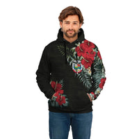 Black pullover hoodie worn by model with red hibiscus and palm-leaf print on chest
