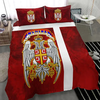 Red duvet with Serbian eagle crest over white center stripe and two matching red pillows