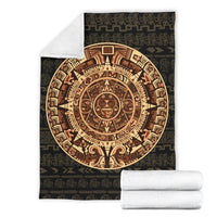 Folded dark blanket set with bold Mayan sun circle and tree of life motif
