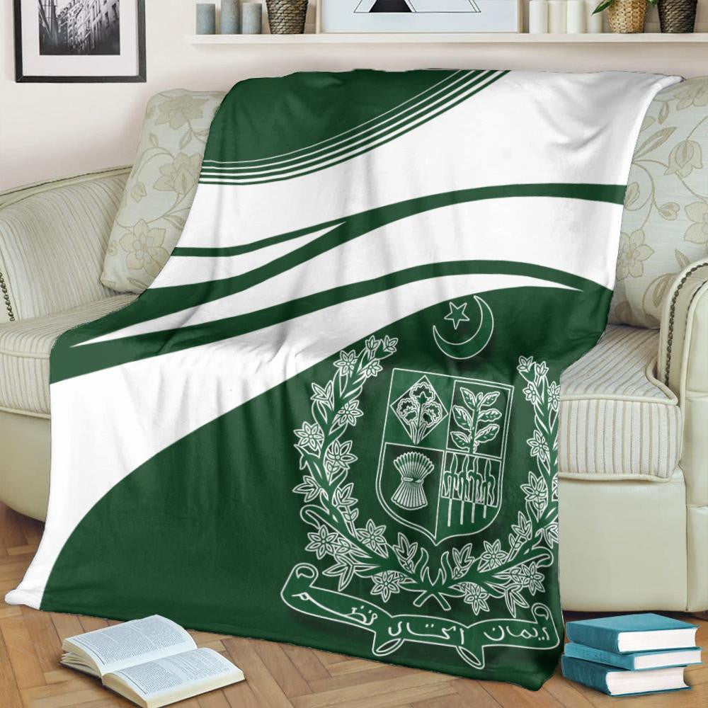 Green-and-white Pakistan coat of arms blanket draped on sofa, central emblem visible