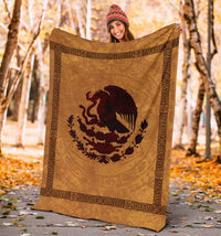 Gold blanket with dark red coat-of-arms bird, held up outdoors