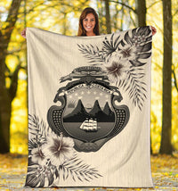 Beige tropical Costa Rica blanket with central emblem and hibiscus-style floral graphics