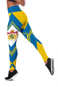 Side view colorful leggings with blue/yellow panels, zigzag trim, and central crest print