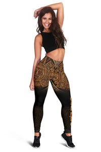 Full-body view: black Aztec calendar leggings with gold-brown geometric and face motifs.
