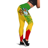 Close-up of Guyana crest on multicolor leggings, green-and-yellow with red side panel