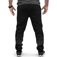 Black joggers with front slash pockets and dark star/emblem graphic on lower calves