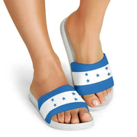 Honduras flag slide sandals on feet, gray footbeds with blue-and-white star front strap