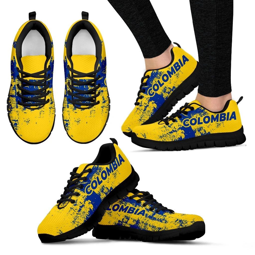 Pair of yellow lace-up sneakers with blue “COLOMBIA” logo, black sole