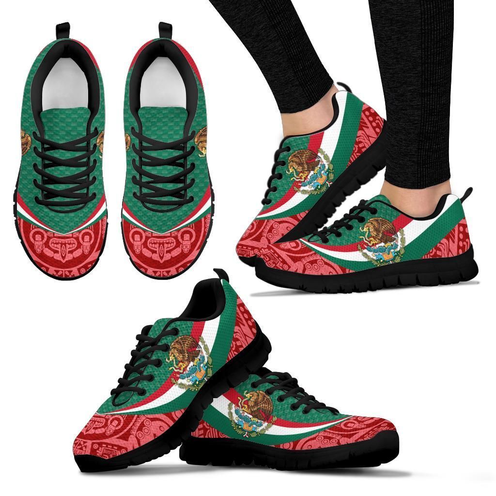 Wearing black sole sneakers: green stripe, red Aztec-style print, and coat of arms emblem