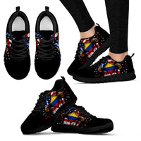 Front view of black sneakers with open hand Colombia flag print, black laces