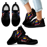Black sneakers worn with open hand Colombia flag print, black sole