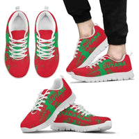 Guyana smudge sneakers on feet, red upper with green “GUYANA” text, white laces, white sole