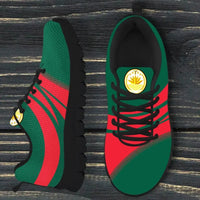 Close-up of green/red sneakers with black sole, laces, and gold Bangladesh emblem