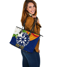 Blue tote three-quarter view with wheel graphic, red sun arc accents, floral front pocket
