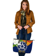 Blue patterned tote with wheel graphic and floral patch, black straps, top zipper detail