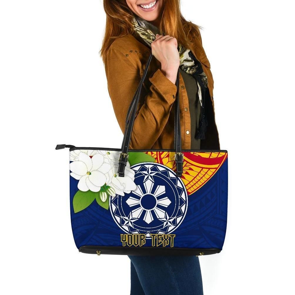Blue tote with wheel graphic, white flower patch, and 'YOUR TEXT' print, black handles